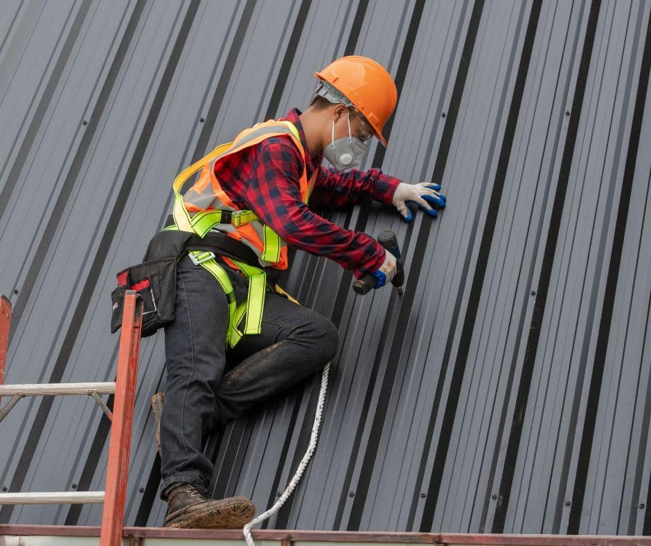 a man wearing a safety helmet and gloves working on a roof