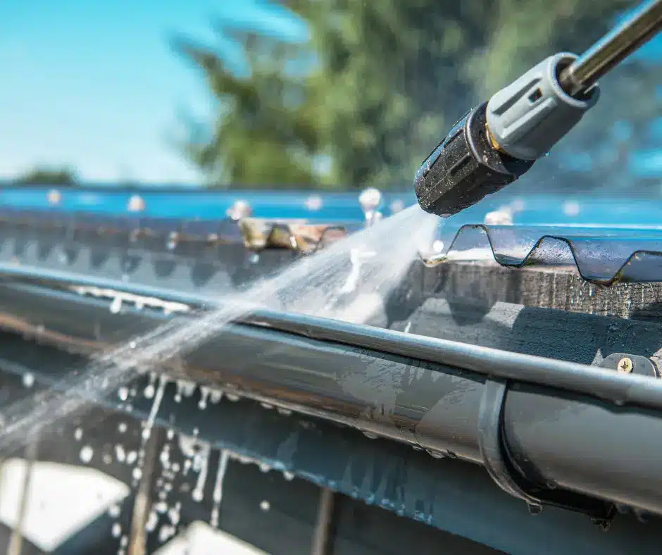 a person spraying water on a gutter