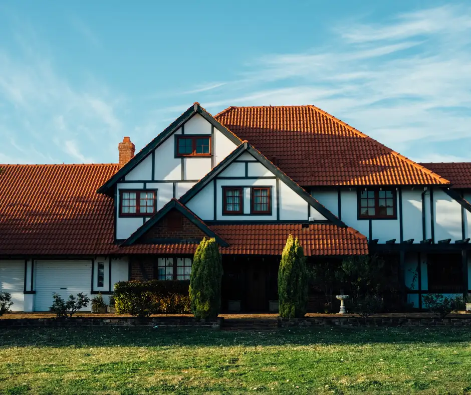 a large house with a lawn and trees