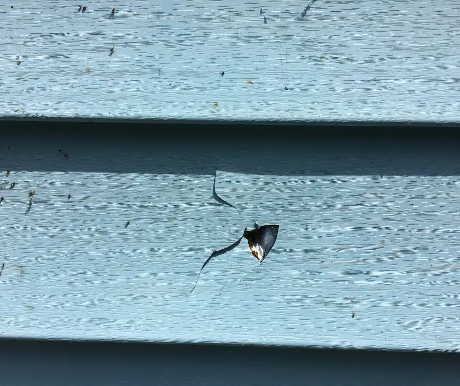 a hole in a blue siding