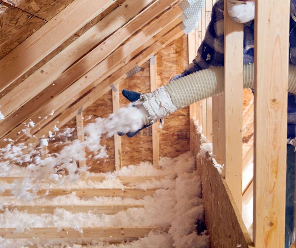 a person in a blue glove pouring snow from a pipe into a roof