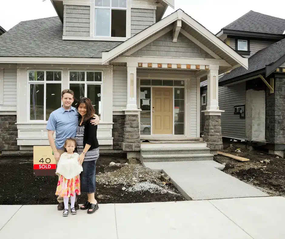 a family posed outside of their newly bought house