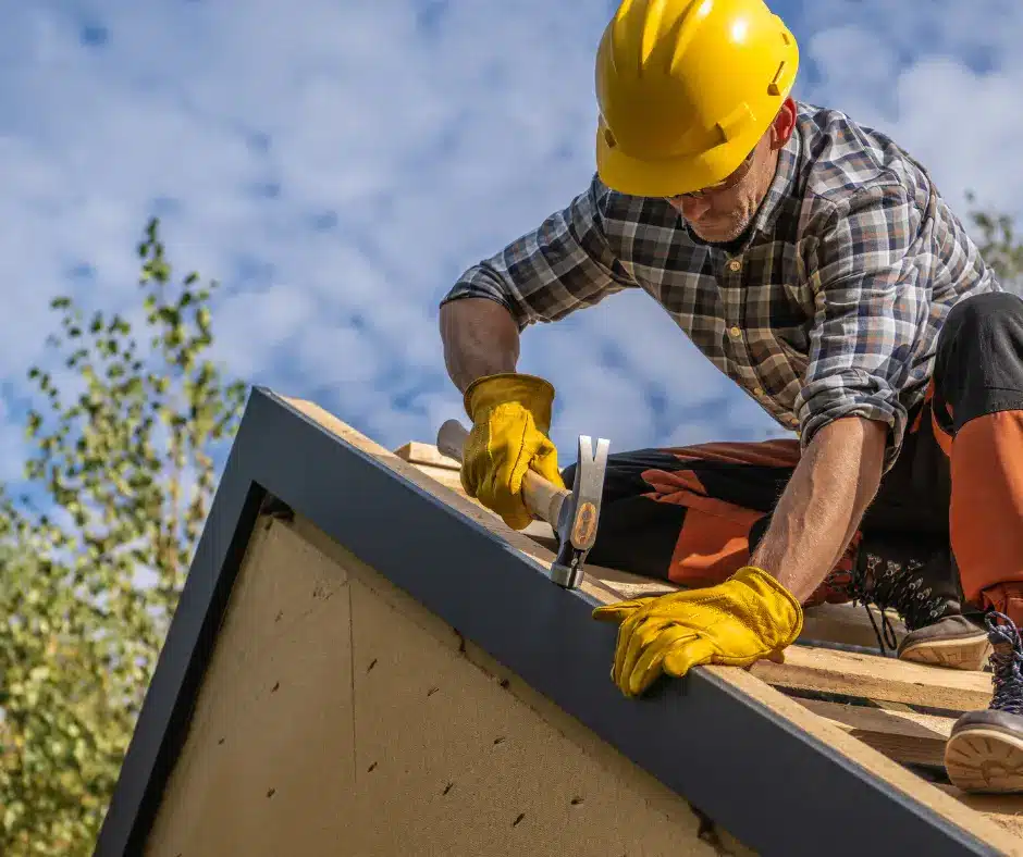 a man wearing a hard hat and gloves working on a roof