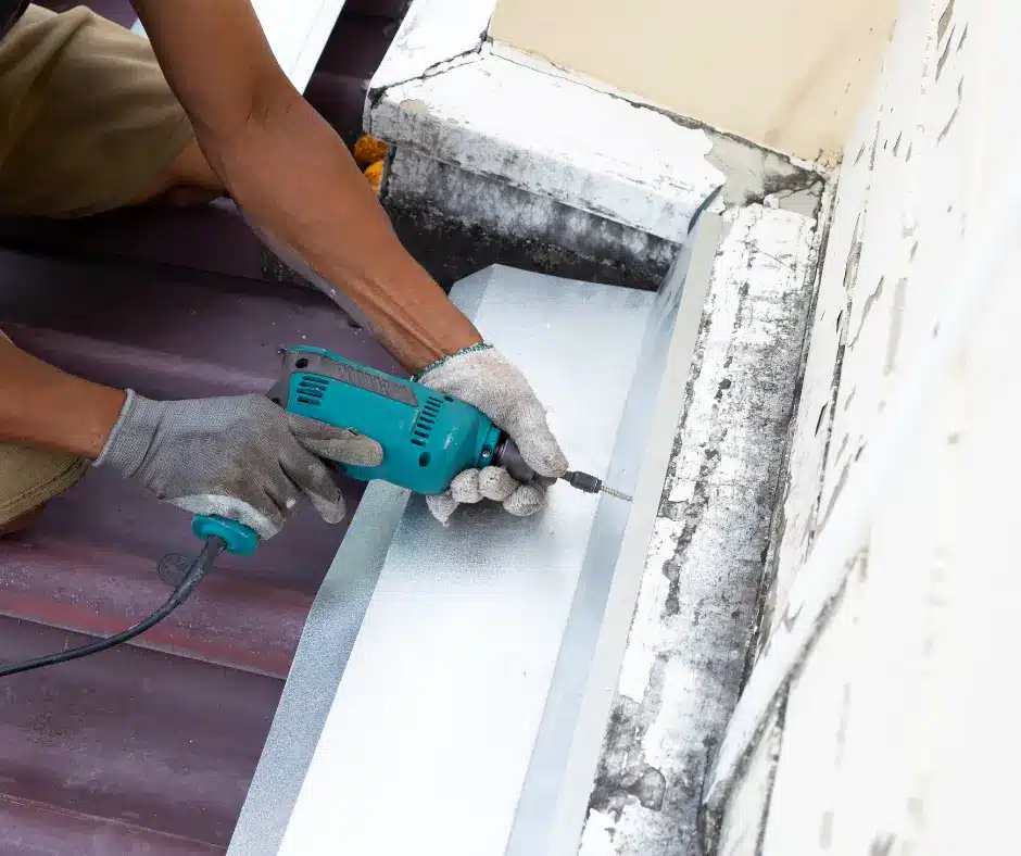 a person holding a drill doing a roof leak repair