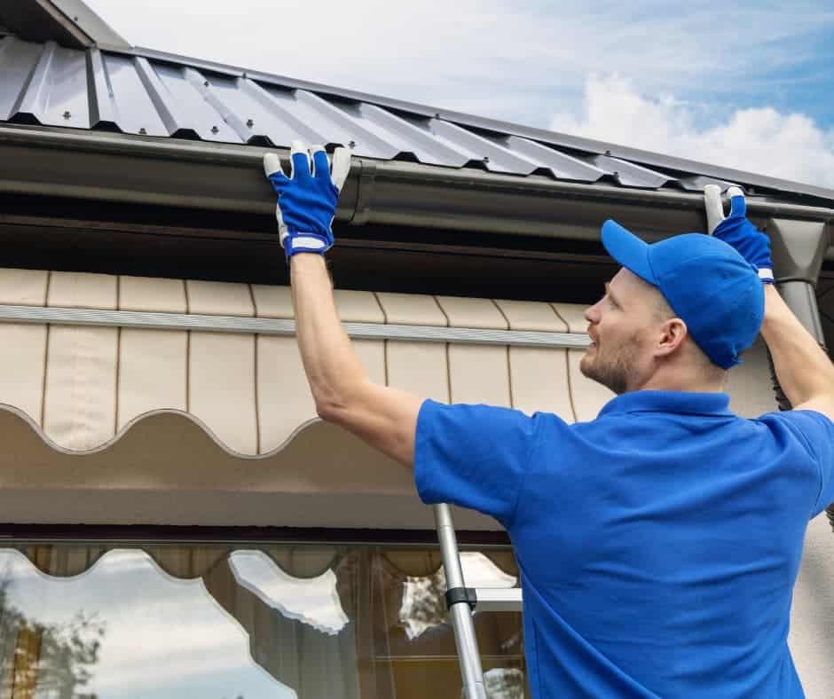 a man wearing blue uniform and holding a metal gutter