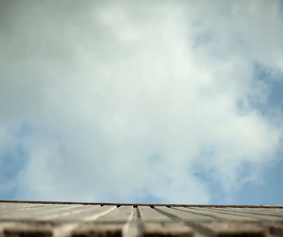 a looking up at a roof with clouds in the sky