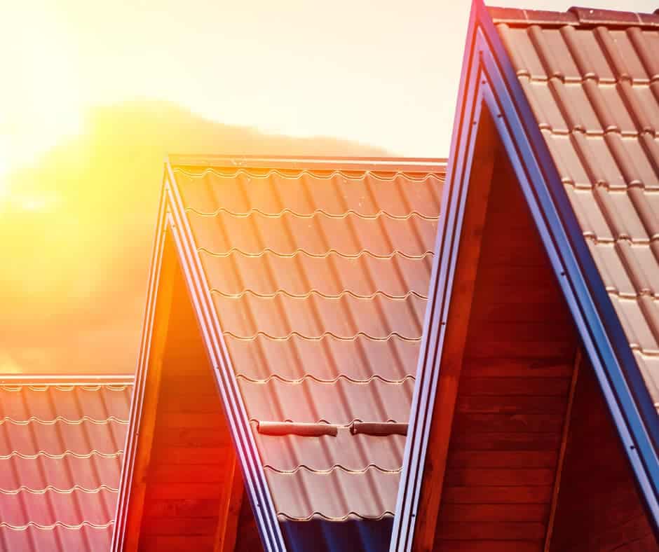 a group of roof tops with the sun shining through