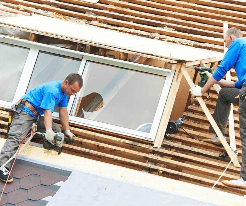 a couple of men working on a roof