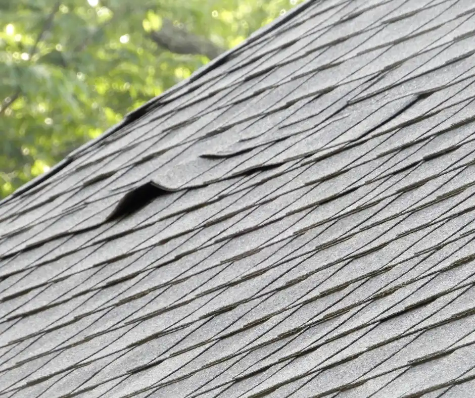 a close up of a roof with curled shingles