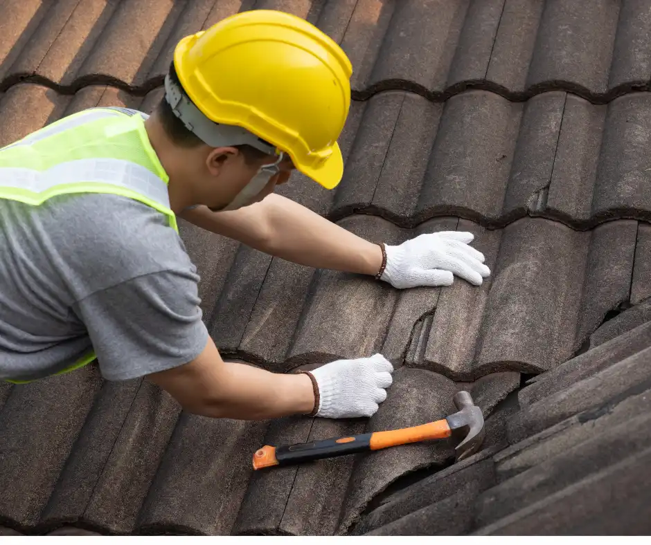 a man wearing a hard hat and gloves working on a roof