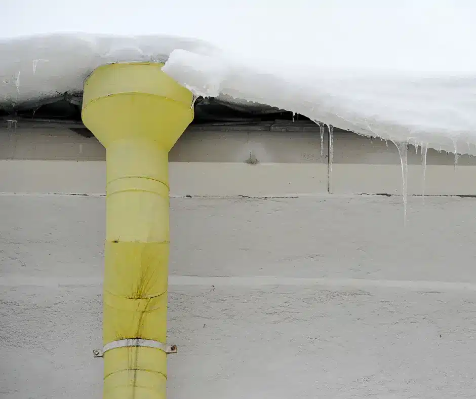 a yellow pipe with snow on the roof