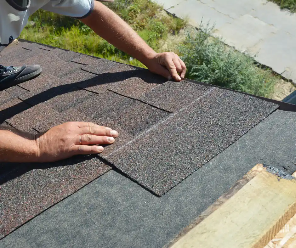 a person installing a shingle on a roof