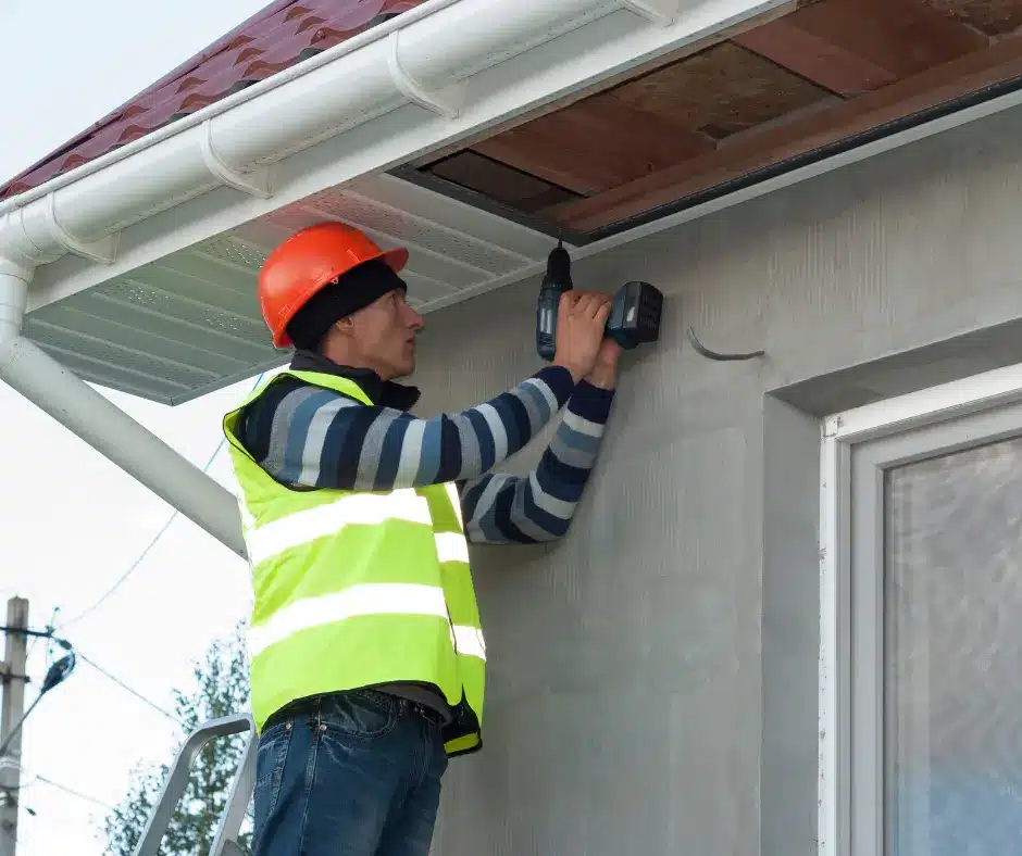 a man in a reflective vest using a drill