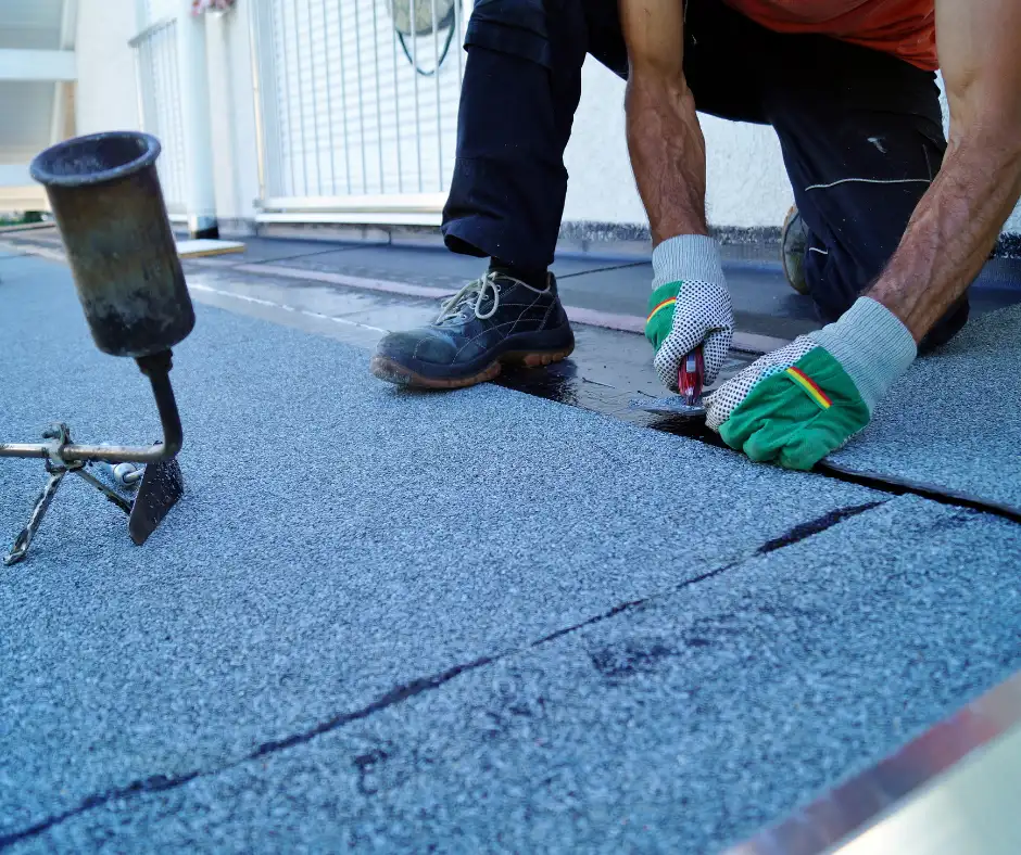 a man working on a roof and installing roof felt