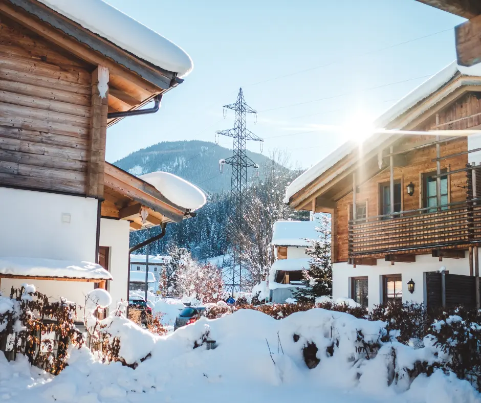 a snow covered houses in a village. what a holiday roofing looks like