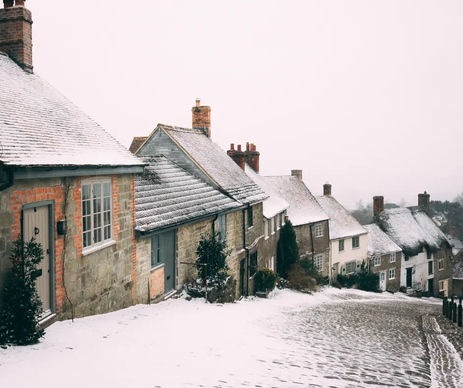 a snow covered street with houses