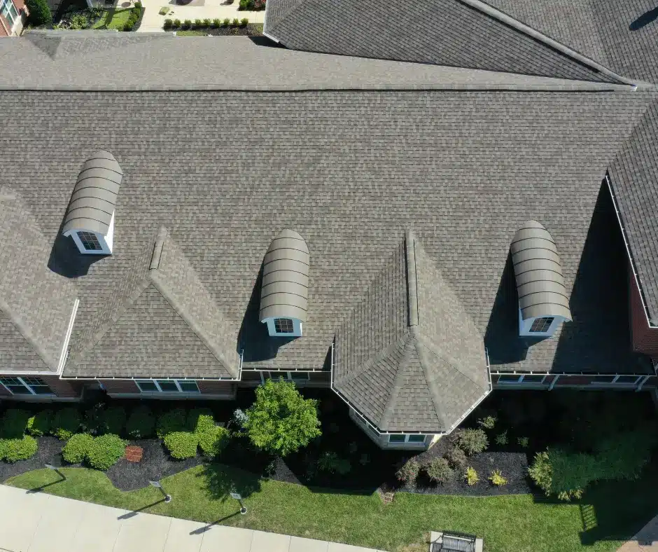 a roof of a house with a driveway and trees