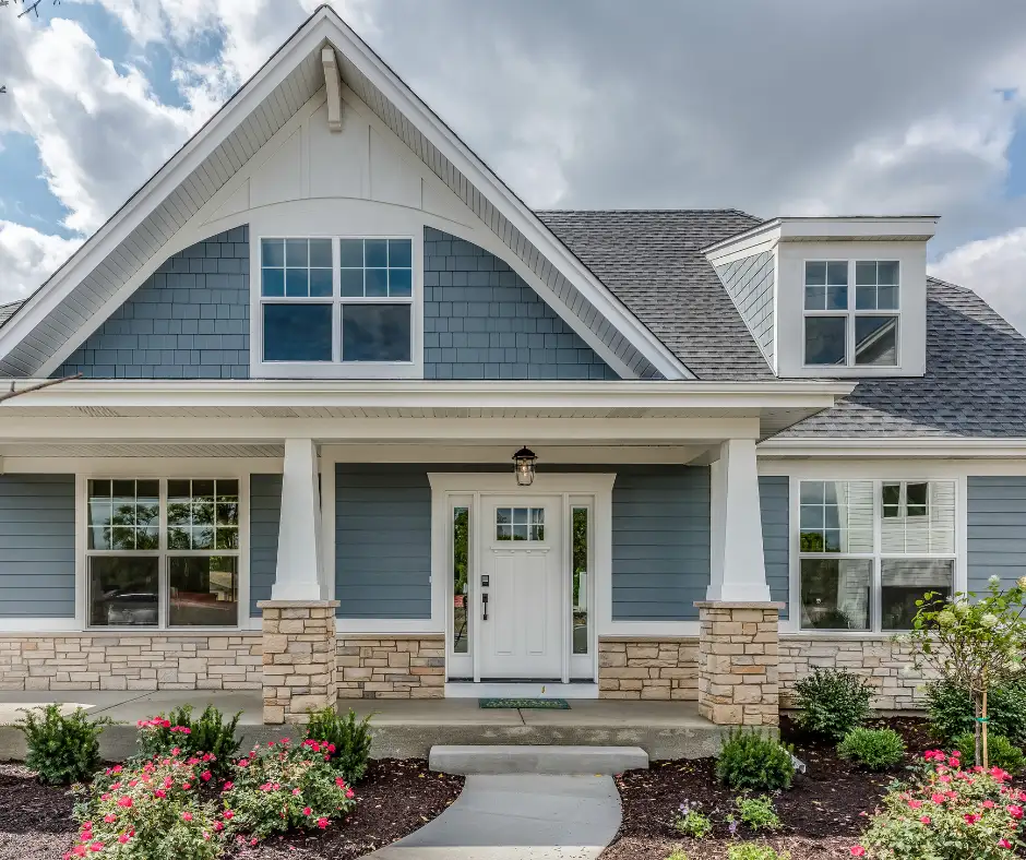 a house with asphalt shingles, porch and a stone walkway